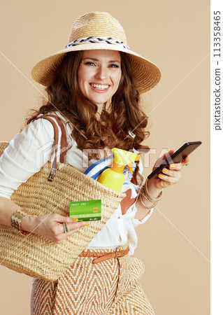 smiling elegant woman in blouse and shorts isolated on beige smiling elegant woman in blouse and shorts isolated on beige 113358465