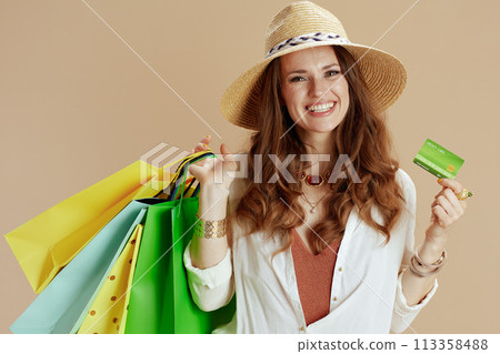 smiling trendy female in blouse and shorts isolated on beige smiling trendy female in blouse and shorts isolated on beige 113358488