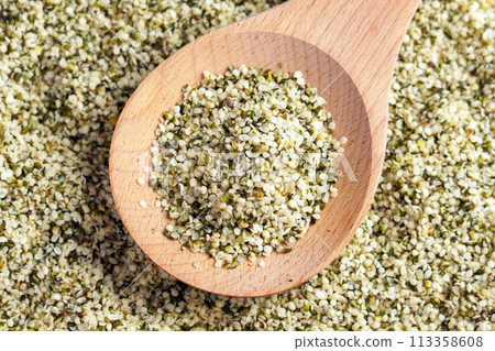 Hemp seeds on a wooden spoon close up. Alimentary food supplement 113358608