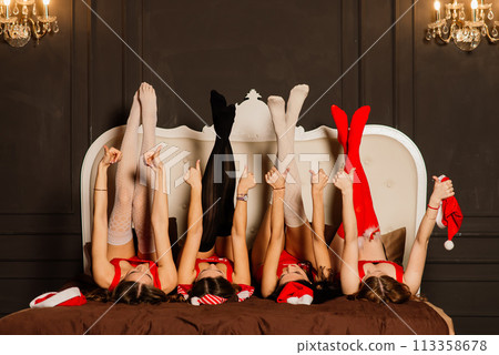 Four pretty women with curly hair and red Christmas lingerie. New year background. Four pretty women with curly hair and red Christmas lingerie. New year background. 113358678