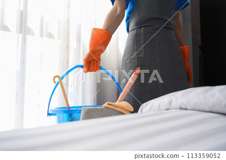 Cropped shot of cleaner woman in rubber gloves holding a basket with cleaning supplies Cropped shot of cleaner woman in rubber gloves holding a basket with cleaning supplies 113359052