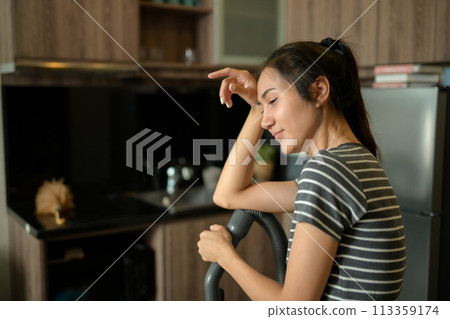 Young housewife wiping sweat from her forehead tired from housework Young housewife wiping sweat from her forehead tired from housework 113359174