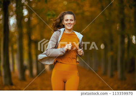 happy trendy woman in fitness clothes in park running happy trendy woman in fitness clothes in park running 113359970