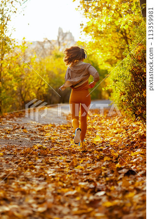 stylish woman in fitness clothes in park running stylish woman in fitness clothes in park running 113359981