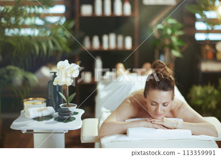 relaxed modern woman in spa salon laying on massage table relaxed modern woman in spa salon laying on massage table 113359991