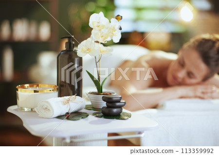 Relaxed female in spa salon laying on massage table Relaxed female in spa salon laying on massage table 113359992