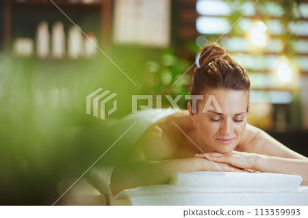 relaxed modern woman in spa salon laying on massage table relaxed modern woman in spa salon laying on massage table 113359993
