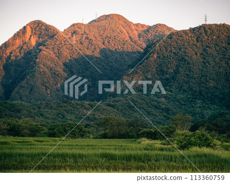 Morning sunrise illuminates the mountains 113360759