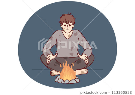 Homeless man in dirty clothes warms hands sitting by fire trying to survive due to lack of own home 113360838