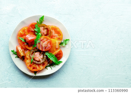 Fresh tomato and rocket salad. A variety of tomatoes of different sorts Fresh tomato and rocket salad. A variety of tomatoes of different sorts 113360990
