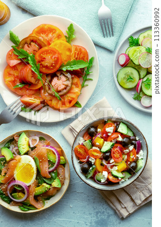 Fresh salads, overhead flat lay shot of an assortment. Variety of plates Fresh salads, overhead flat lay shot of an assortment. Variety of plates 113360992