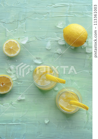 Lemonade. Lemon water drink with ice. Two glasses and fruits on blue Lemonade. Lemon water drink with ice. Two glasses and fruits on blue 113361003