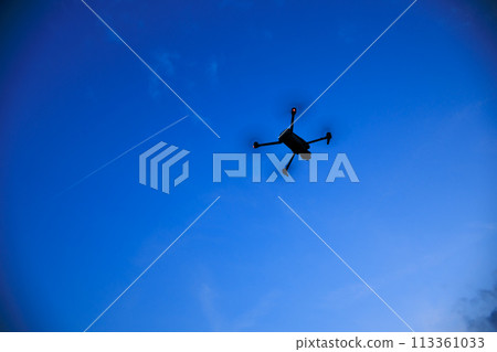 A drone flying in the sunset sky A drone flying in the sunset sky 113361033