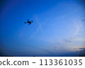 A drone flying in the sunset sky 113361035