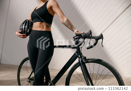 Close up of woman in sportswear is standing with bike and protective helmet before cycling in city Close up of woman in sportswear is standing with bike and protective helmet before cycling in city 113362142
