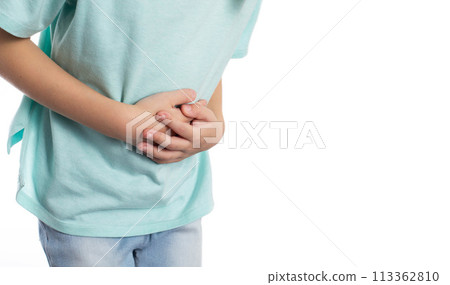 A child holds his stomach with his hands on a white background, close-up. Abdominal pain in children due to helminths, weight loss and poor health. Copy space for text, isolate 113362810