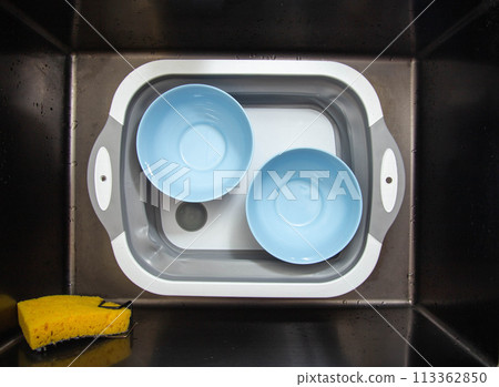 Two blue clean plates in the sink basin. The concept of washing and cleaning dishes from dirt using an ecological oxygen cleaner. 113362850