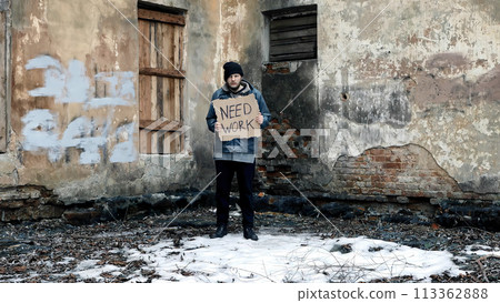 Homeless holds piece of cardboard with inscription Need Work. Refugee is looking for job. Male tramp in dirty clothes. Below poverty line. Bearded fugitive beggar. Immigrant. Drunkenness Homeless holds piece of cardboard with inscription Need Work. Refugee is looking for job. Male tramp in dirty clothes. Below poverty line. Bearded fugitive beggar. Immigrant. Drunkenness 113362888