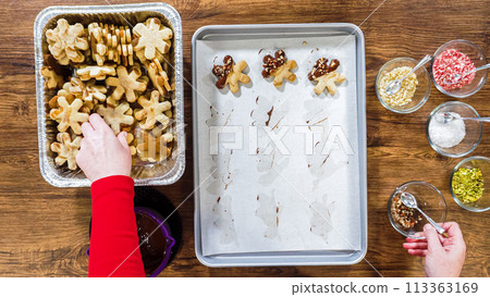 Flat lay. Creating snowflake-shaped cutout sugar cookies, dipped in chocolate, and adorned with different toppings. Flat lay. Creating snowflake-shaped cutout sugar cookies, dipped in chocolate, and adorned with different toppings. 113363169