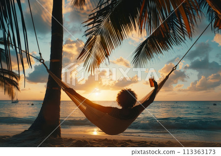 Person relaxing in a hammock between palm trees 113363173