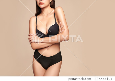 Confident beautiful young asian woman posing in black lingerie on beige background, Perfect body, 113364195