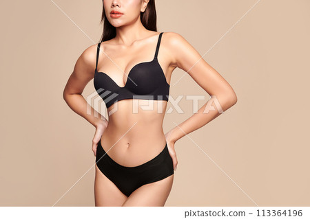 Confident beautiful young asian woman posing in black lingerie on beige background, Perfect body, Confident beautiful young asian woman posing in black lingerie on beige background, Perfect body, 113364196