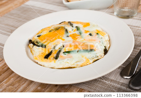 Closeup of fried eggs with asparagus at plate 113366398