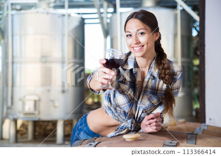 Woman is tasting wine at Italian wine factory Woman is tasting wine at Italian wine factory 113366414