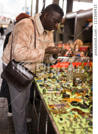Man looking at used items at a flea market Man looking at used items at a flea market 113366415