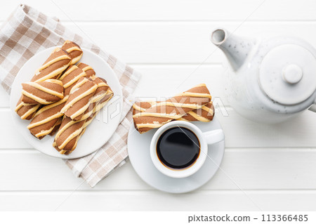 Classic Striped Cookies and coffee cup on white table. Top view. Classic Striped Cookies and coffee cup on white table. Top view. 113366485