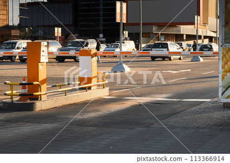 Automatic barrier gates for supermarket parking lot. Security system for car park entry to shopping mall. Vehicle entrance with boom barriers and control tickets machine Automatic barrier gates for supermarket parking lot. Security system for car park entry to shopping mall. Vehicle entrance with boom barriers and control tickets machine 113366914