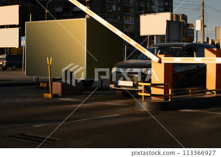 Car approaching to automatic barrier gates for supermarket parking lot. Security system for car park entry to shopping mall. Vehicle entrance with boom barriers and control tickets machine 113366927