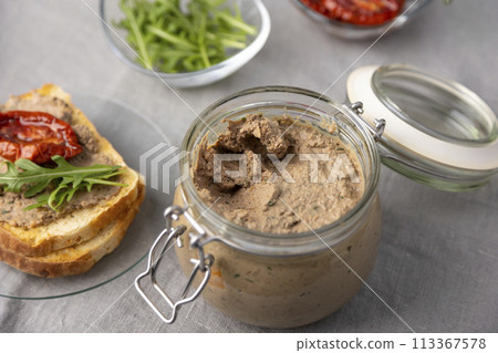 Chicken liver pate with wheat bread, arugula, sun-dried tomatoes and black tea. Homemade traditional rustic cuisine. Breakfast or snack option. Selective focus, close-up. 113367578