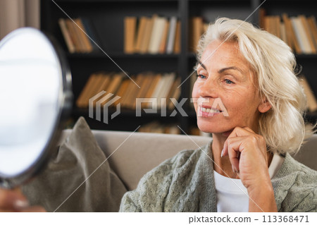 Love yourself. Beautiful old mature woman enjoying mirror reflection. Senior adult older lady looking at mirror confident happy on sofa at home. Woman doing daily morning beauty routine. Self love Love yourself. Beautiful old mature woman enjoying mirror reflection. Senior adult older lady looking at mirror confident happy on sofa at home. Woman doing daily morning beauty routine. Self love 113368471