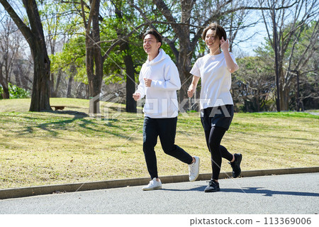 Men and women running side by side outdoors 113369006
