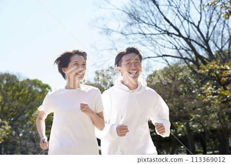 Men and women running side by side outdoors Men and women running side by side outdoors 113369012
