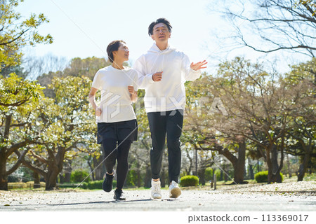 Men and women running side by side outdoors 113369017