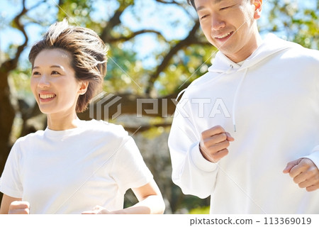 Men and women running side by side outdoors 113369019