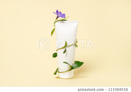A blank white cosmetic tube and twigs with leaves and flowers wrap around it, natural skincare A blank white cosmetic tube and twigs with leaves and flowers wrap around it, natural skincare 113369538