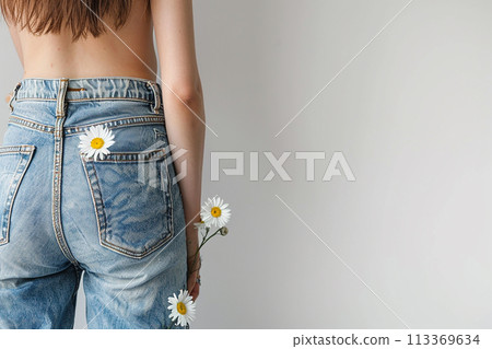 A woman is holding a bunch of flowers in her jeans pocket. Concept of playfulness and whimsy 113369634