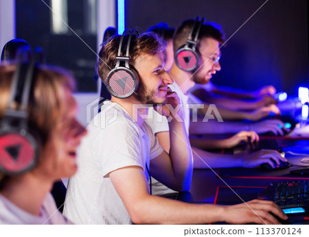 Team of gamers playing video game on PC at computer club cyber sport tournament. E-sport championship. 5 players in headset. Multiplayer online battle, tactical first-person shooter. 113370124