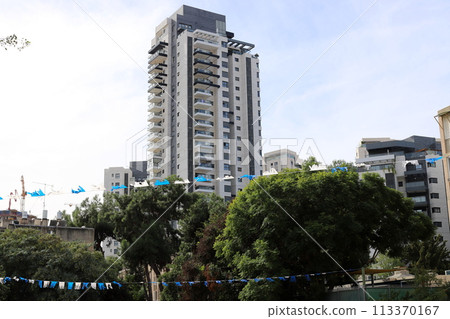 Tel Aviv city against the backdrop of tall green plants. 113370167