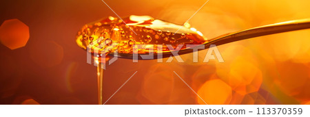 drop of honey dripping from a spoon, highlighting the thick texture and golden color of the sweet liquid. Generative AI 113370359