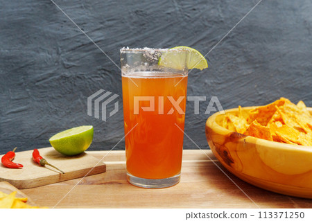 Mexican cocktail, michelada, made with beer and tomato juice. Selective focus Mexican cocktail, michelada, made with beer and tomato juice. Selective focus 113371250