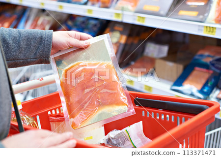 Pack of salmon in hand at store 113371471