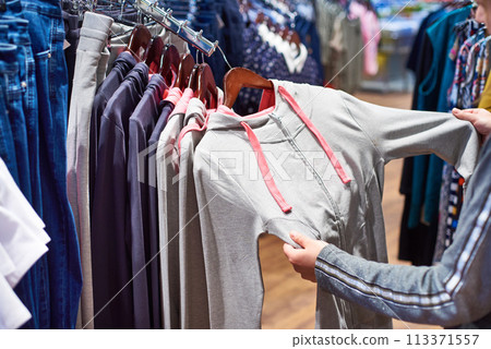 Buyer woman chooses clothes in store 113371557