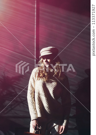 Studio portrait of beautiful woman with a curly blond hair, posing on gray background. 113371927