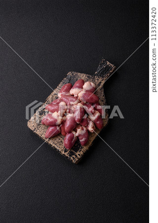 Raw chicken hearts with salt, spices and herbs Raw chicken hearts with salt, spices and herbs 113372420