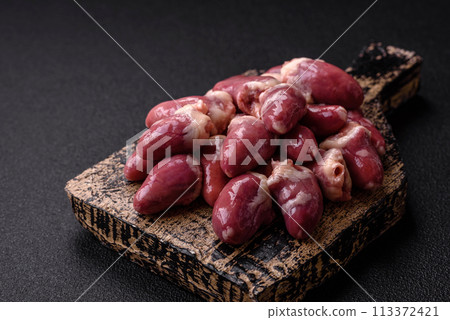 Raw chicken hearts with salt, spices and herbs 113372421