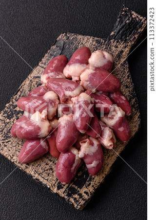 Raw chicken hearts with salt, spices and herbs 113372423